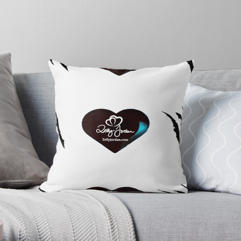 A decorative pillow with a black heart design and the text 'Zelly Jordan' along with the website 'Zellyjordan.com', placed on a light gray couch.