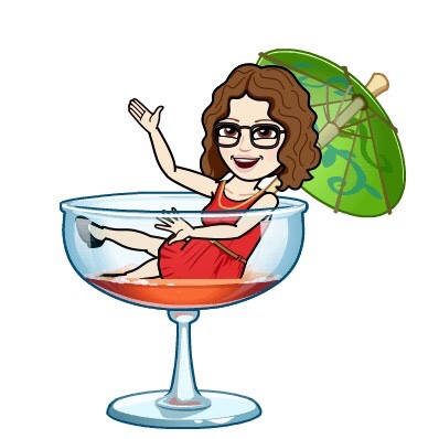 A cartoon character in a red dress sitting in a large cocktail glass with an umbrella, waving and smiling cheerfully.