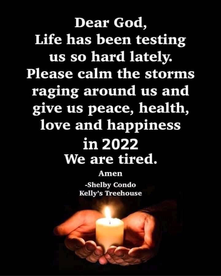 A pair of hands holding a lit candle with a black background, featuring text that expresses a heartfelt prayer for peace, health, love, and happiness in 2022.